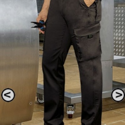 Homem com calças pretas de trabalho e sapatos de segurança em ambiente industrial