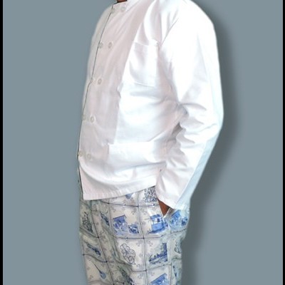 Homem com roupa de chef branca e calças estampadas azul e branco.