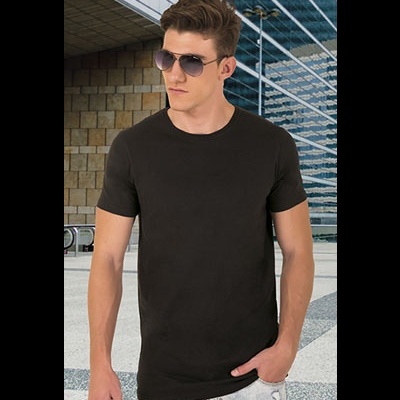 Homem jovem usando camiseta preta básica de manga curta com calças claras em ambiente urbano.