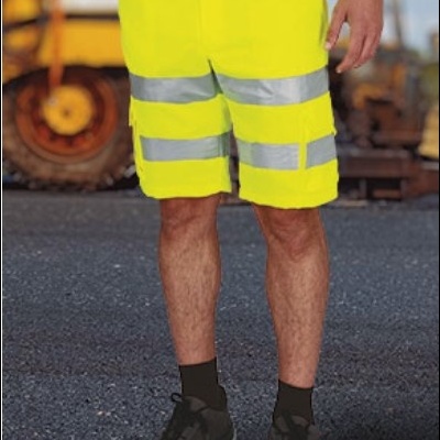 Homem com calções amarelos fluorescentes de trabalho e faixas refletoras em ambiente industrial