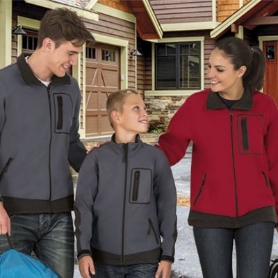 Casacos vermelhos e cinzentos com bolsos pretos usados por três pessoas em frente a casa