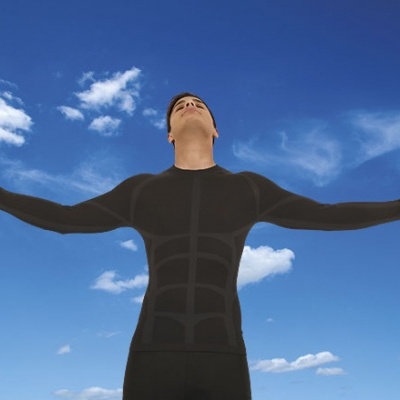 Homem com camisa térmica preta e braço aberto sob céu azul