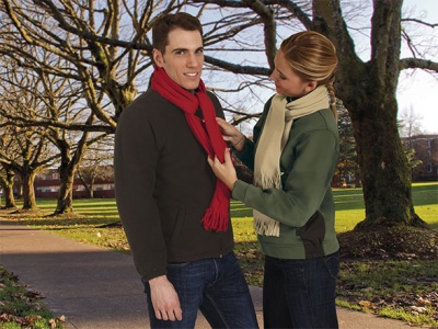 Homem e mulher ao ar livre com camisolas e cachecóis em parque