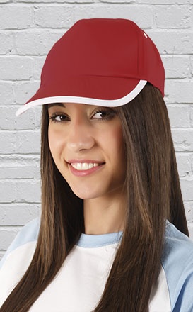 Boné vermelho com aba branca usado por mulher jovem de cabelo castanho contra parede branca