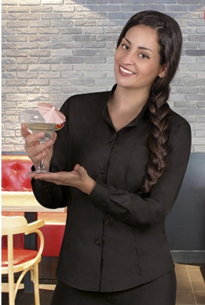 Mulher com camisa preta segurando taça de cocktail com guarda-chuva de papel rosa.
