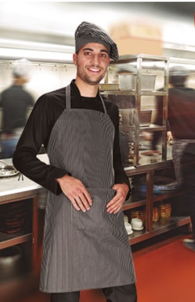 Cozinheiro com avental e chapéu cinzentos numa cozinha profissional
