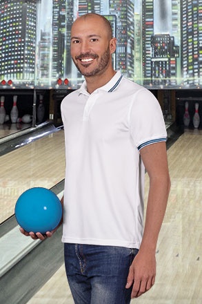 Homem a jogar bowling com camisa polo branca e bola azul
