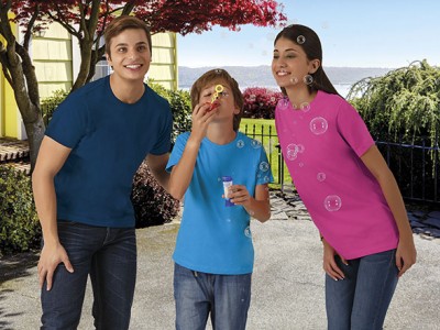 Três pessoas ao ar livre com t-shirts coloridas e bolhas de sabão.