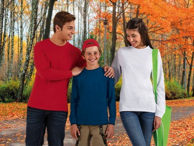 Três pessoas vestindo camisolas de manga comprida coloridas e calças em cenário de outono