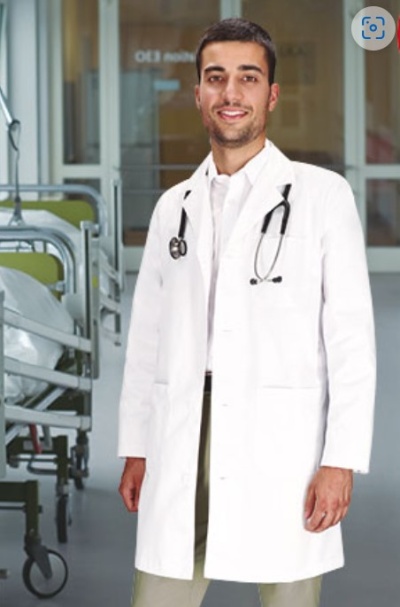 Médico com bata branca e estetoscópio ao pescoço em hospital.