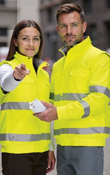 Homem e mulher com coletes amarelos de alta visibilidade e faixas refletoras na rua