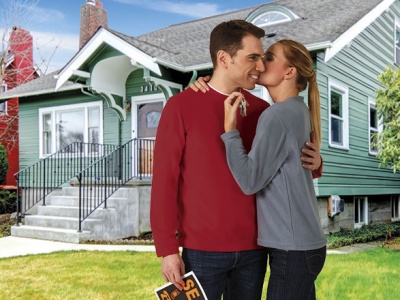 Casal abraçado em frente a casa verde