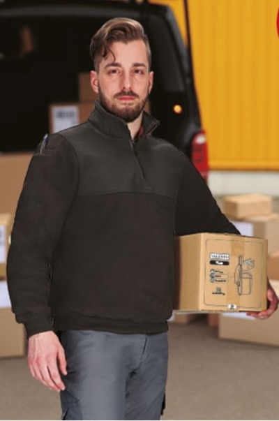 Homem com blusão preto segurando caixa de cartão com texto VISIBILITY e desenho técnico