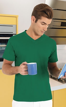 Homem com t-shirt verde segurando caneca azul e lendo livro
