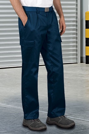 Calças de trabalho azuis com bolsos laterais e sapatos de segurança em ambiente industrial