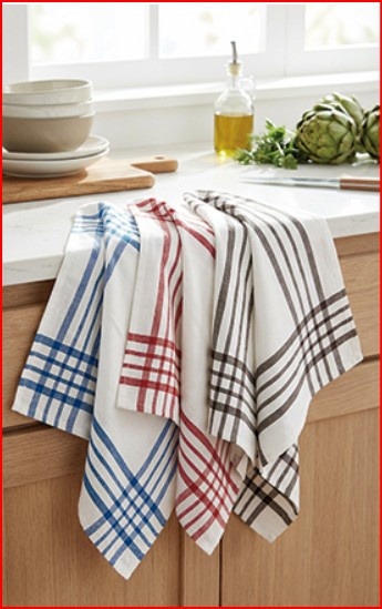 Quatro panos de cozinha com riscas coloridas pendurados numa bancada