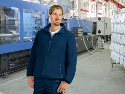 Homem com casaco azul escuro em fábrica industrial