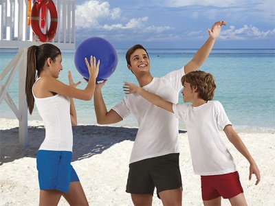 Jovens na praia com roupa casual e bola roxa