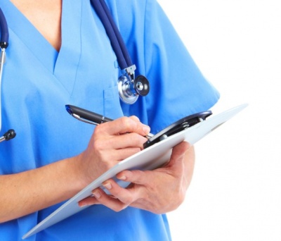 Profissional de saúde em uniforme azul com estetoscópio e prancheta