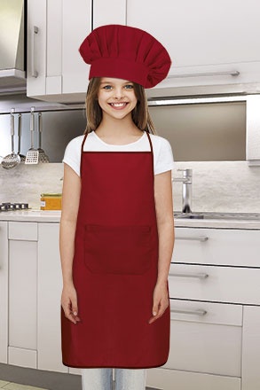 Criança com avental e chapéu de chef vermelhos numa cozinha moderna