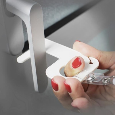 Ferramenta branca com gancho a abrir porta por mão com unhas vermelhas