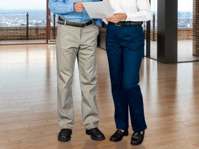 Duas pessoas em espaço interior com calças e camisas, chão de madeira e vista para cidade.