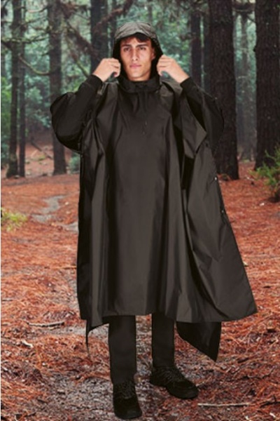 Homem com poncho preto impermeável e capuz em floresta