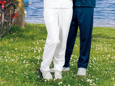 Pessoas com calças desportivas e ténis em relvado junto a lago