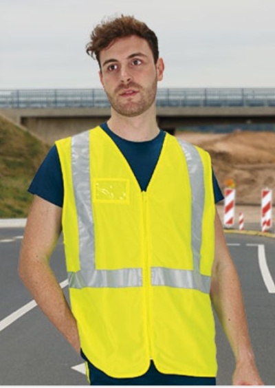 Homem a usar colete de segurança amarelo fluorescente com bandas refletoras em ambiente exterior na estrada