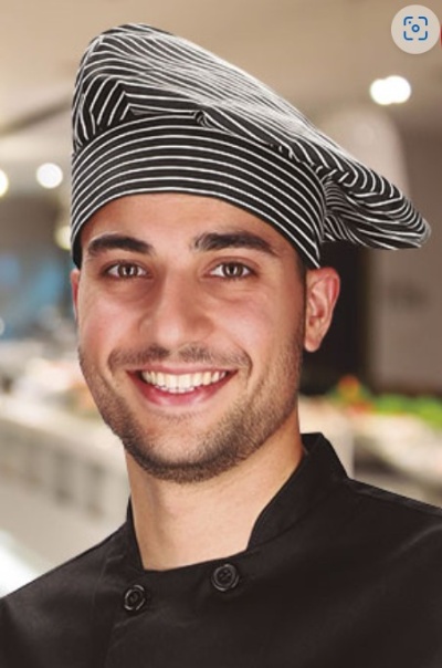 Chefe de cozinha com chapéu preto listrado e uniforme preto.