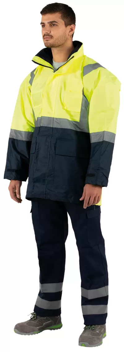 Homem com vestuário de segurança amarelo e azul com faixas refletoras e calçado cinzento