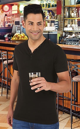 Homem com t-shirt preta e jeans segurando copo num café