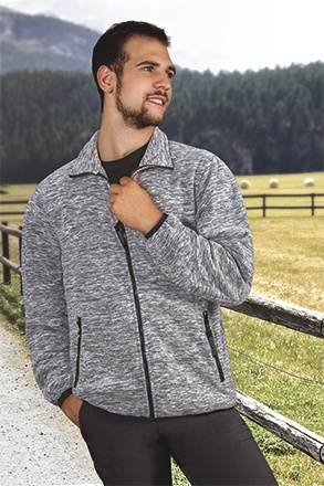 Homem com camisola cinzenta de malha com fechos, em ambiente rural