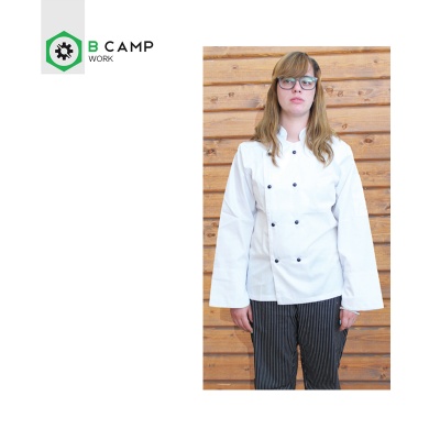 Pessoa com casaco de chef branco e óculos em frente a parede de madeira