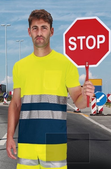 Homem com roupa de sinalização amarela e faixa reflexiva a segurar placa STOP vermelha