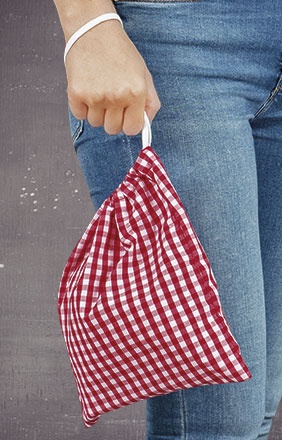 Mala pequena xadrez vermelha e branca segurada à mão