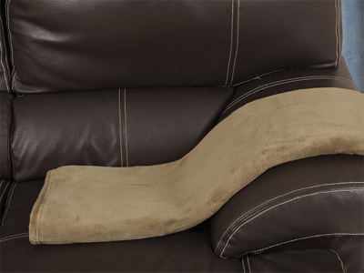 Almofada castanha clara sobre sofá de couro castanho escuro
