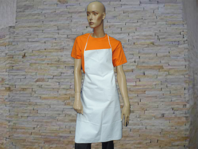 Mannequim com t-shirt laranja e avental branco em frente a parede de pedra