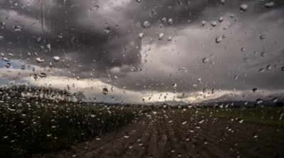 Janela molhada mostrando estrada de terra e céu nublado e escuro