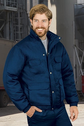 Homem com casaco azul escuro acolchoado em ambiente industrial