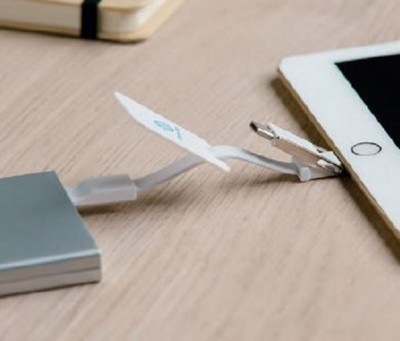 Cabo USB a carregar tablet sobre mesa de madeira