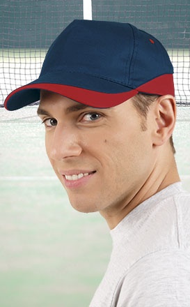 Homem jovem a usar boné azul escuro com aba vermelha num campo de ténis