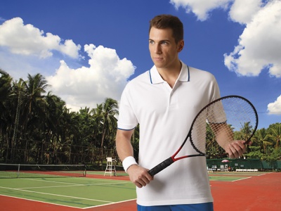 Homem com roupa de ténis segurando raquete numa quadra de ténis ao ar livre