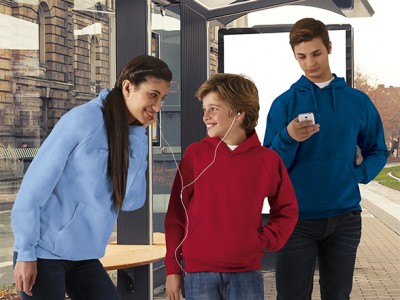 Três jovens com sweatshirts coloridas numa paragem de autocarro