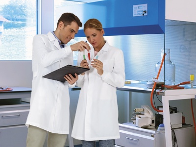 Dois cientistas com batas brancas a analisar tubos de ensaio num laboratório