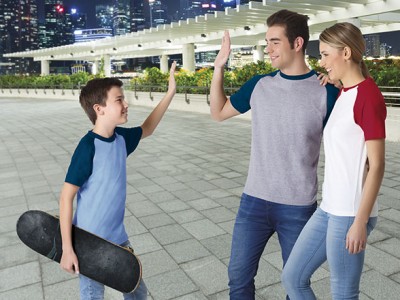 Rapaz com skate e duas pessoas a fazerem 'high five' em zona urbana exterior