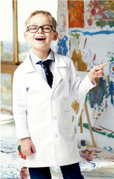 Criança com bata branca de laboratório e óculos em ambiente artístico colorido