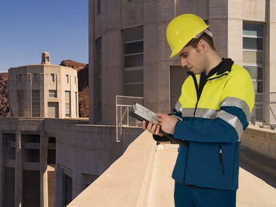 Homem com roupa de proteção e capacete amarelo em ambiente industrial