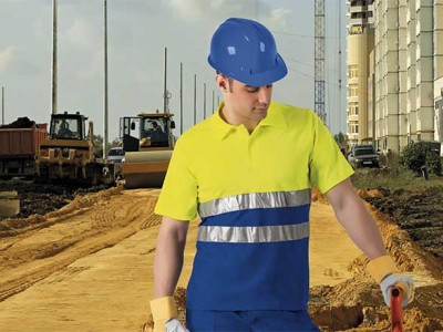 Homem em roupa de segurança azul e amarela numa obra