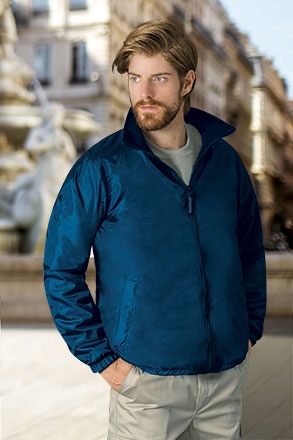 Homem vestido com casaco azul escuro em ambiente urbano ao ar livre